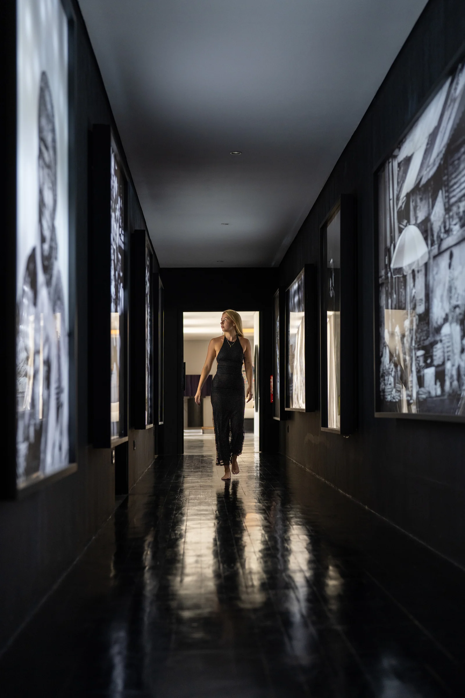 A guest exploring the corridor of Marcio Nicoletti’s illuminated street photographs