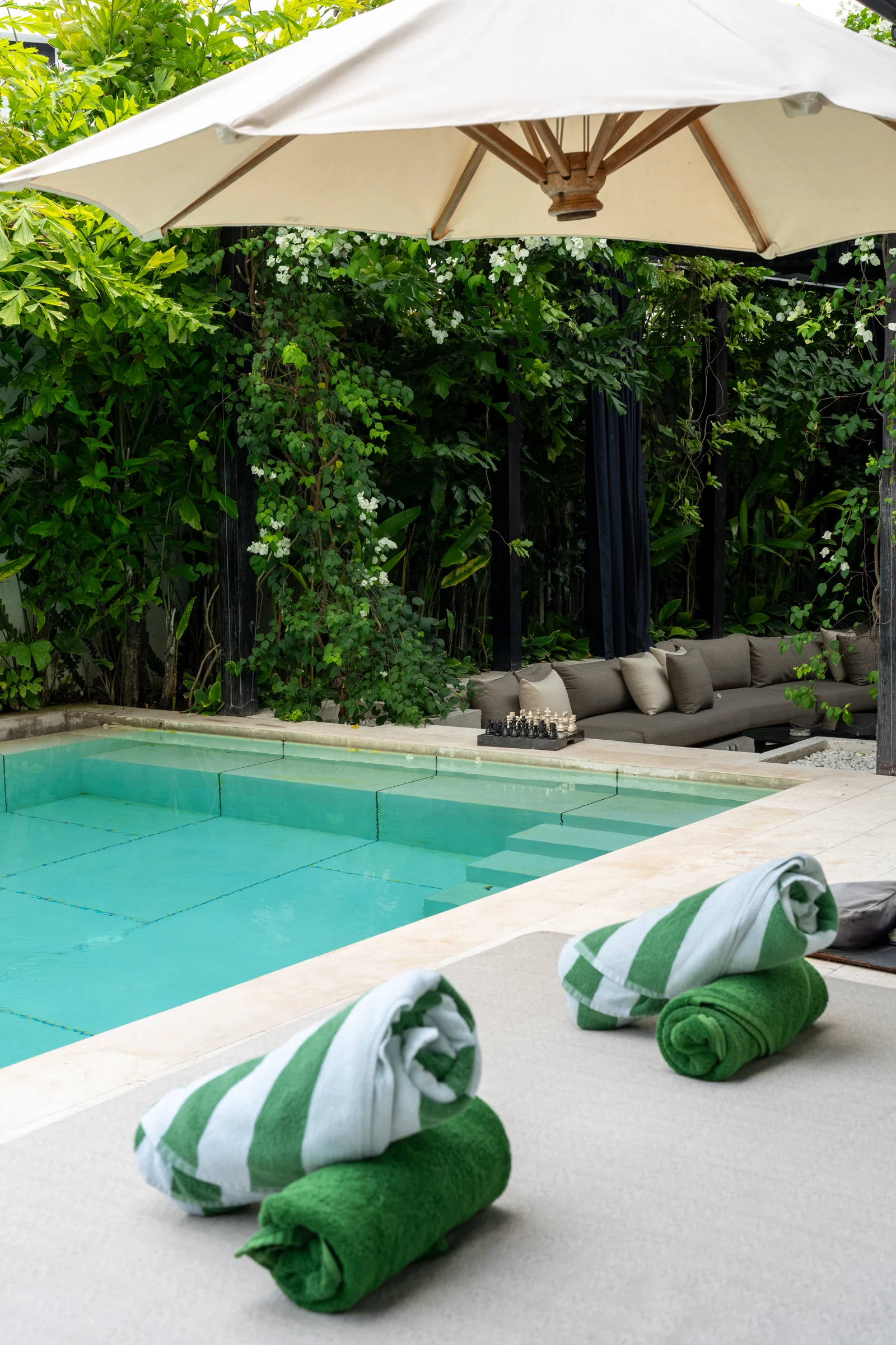 Green and white towels prepared for a swim in the private pool